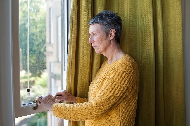 Woman lost in thought looks out a window
